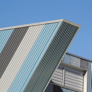 The building appears to be leaning over to one side, and the coloured bands of COLORBOND® Metallic steel that run around the walls add to the impression that this is anything but a static building